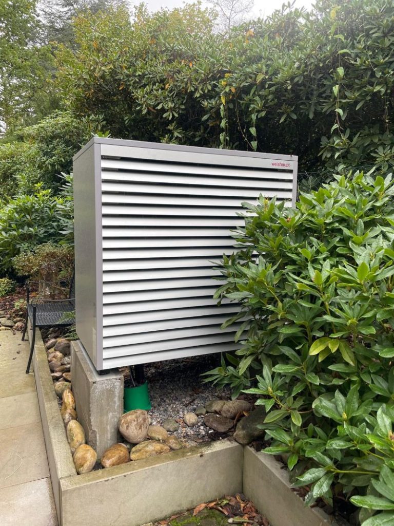 Weishaupt Wärmepumpe montiert auf einem Fundament im Garten eines Hauses