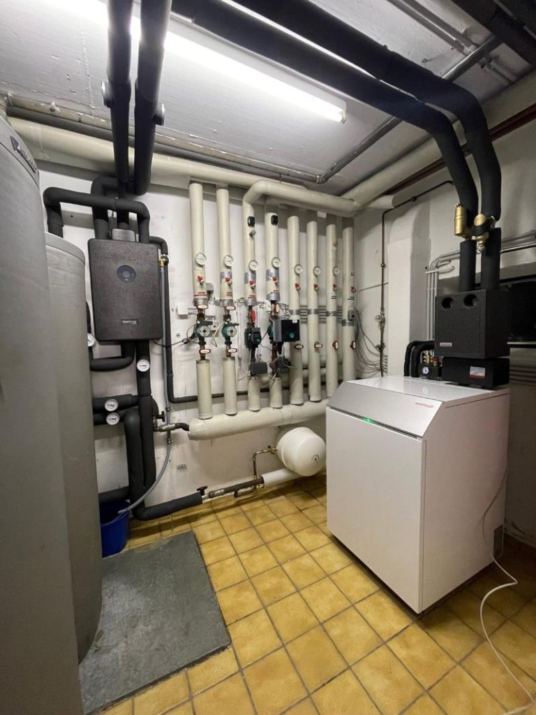 Wärmepumpenanlage und Frischwasserstation in einem Heizraum eines Hauses